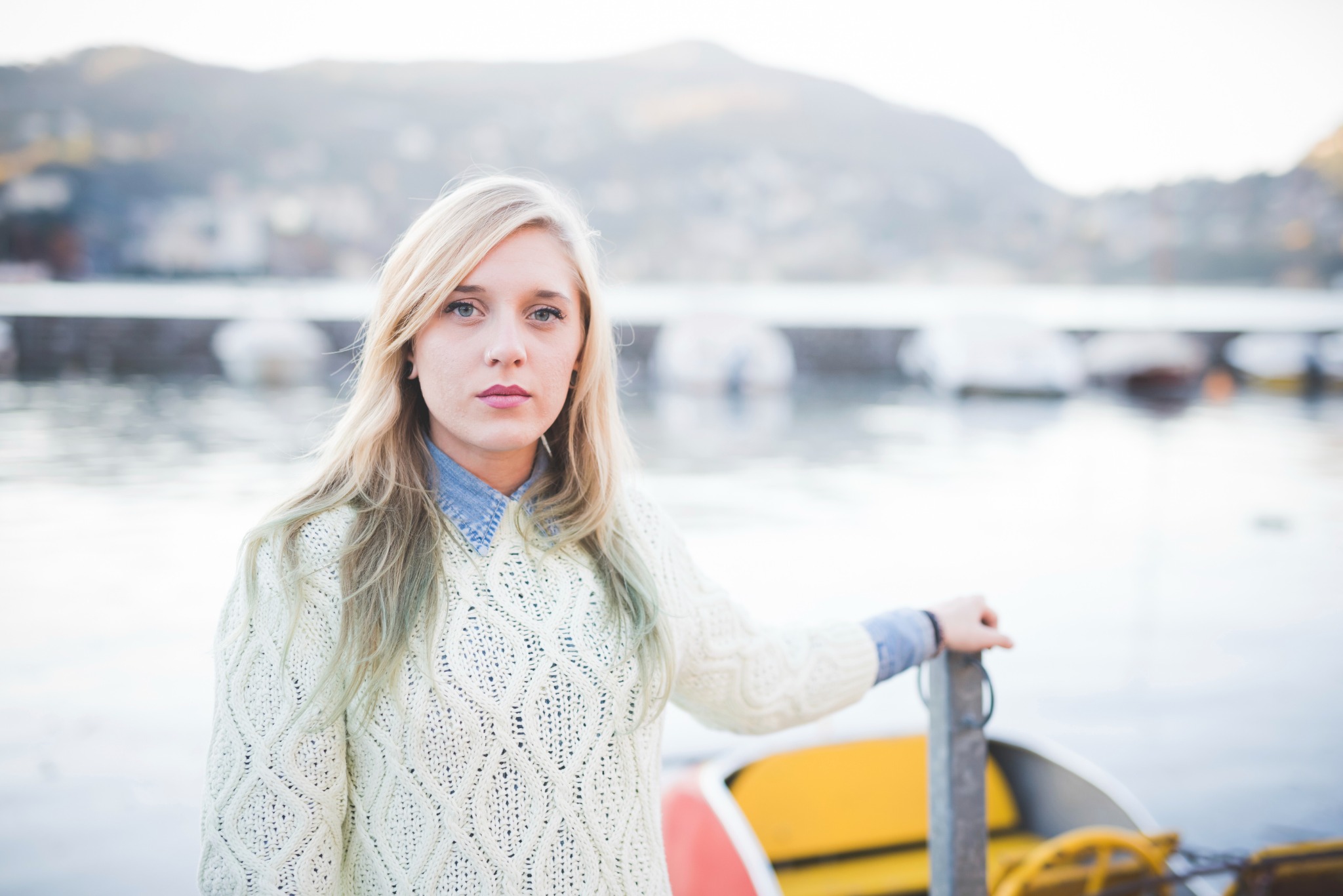 A woman in a light jumper by a lake