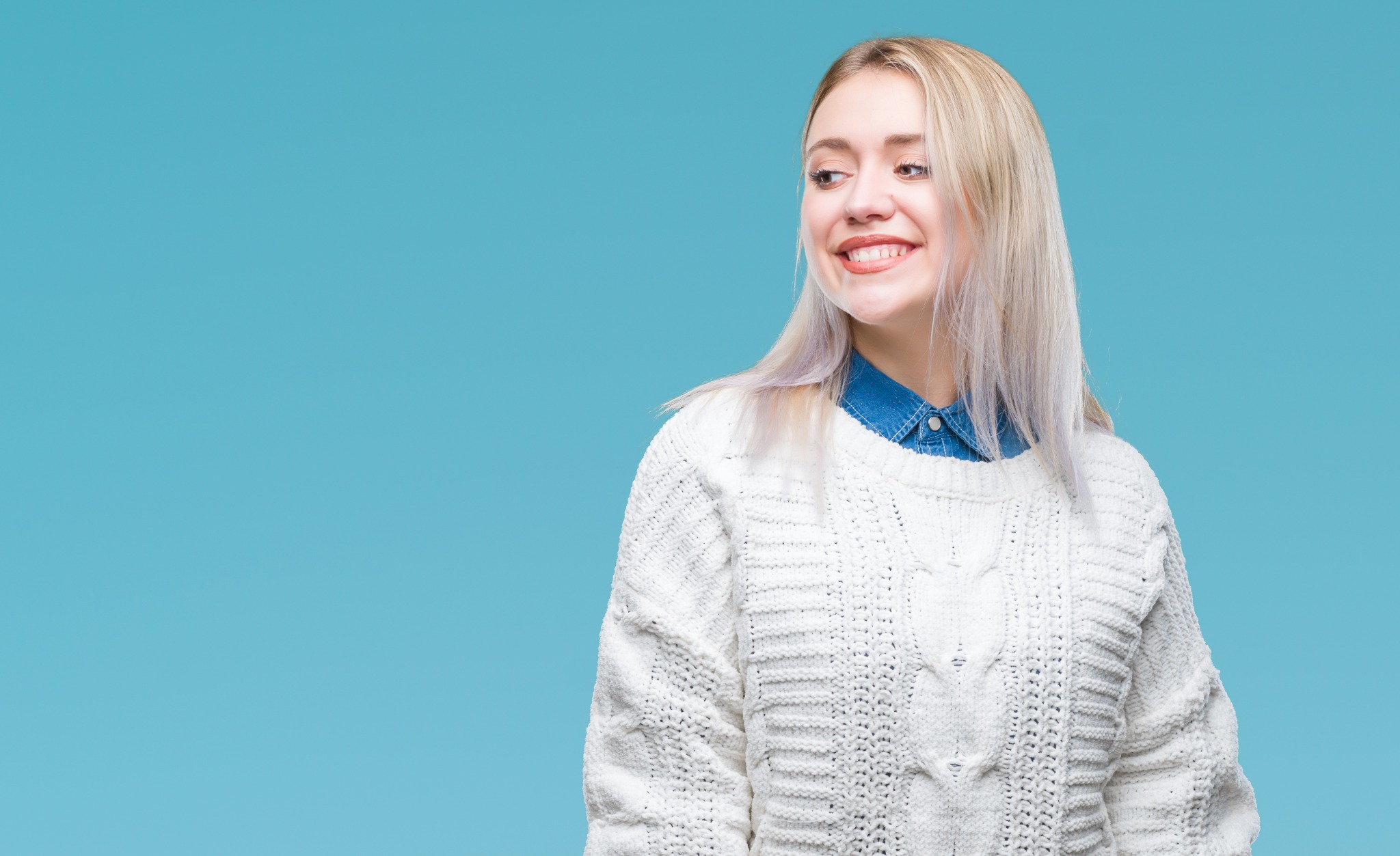 A woman in a white jumper against a light background